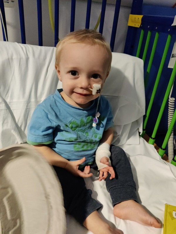 Laura Fanthorpe's son, Arthur, sits in a hospital bed and smiles for the camera, with a tube in his face and a bandage on one arm.  (Image: Laura Fanthorpe)